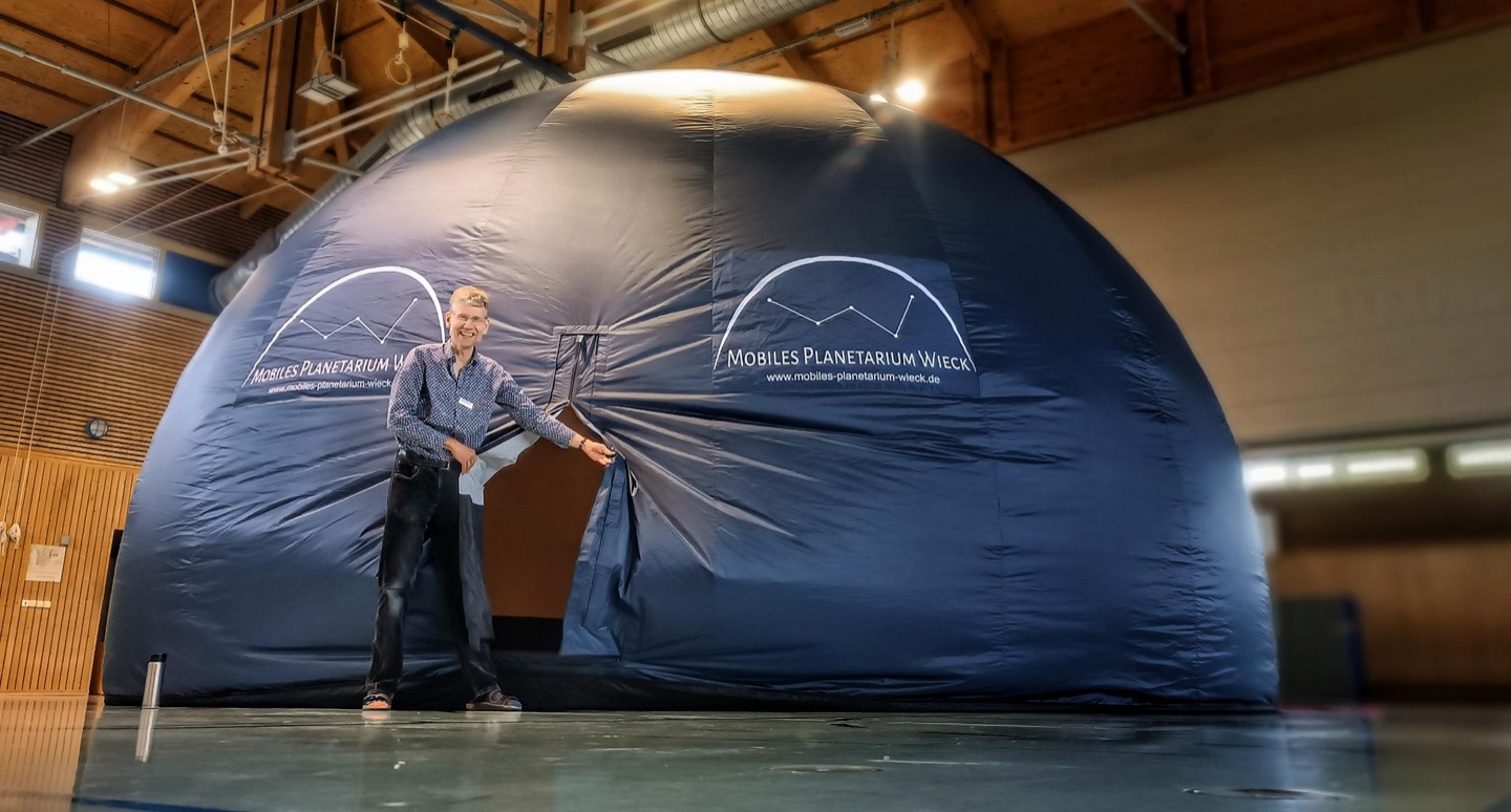 Aufgebaute Planetariumskuppel mit Projektor in einer Schulturnhalle